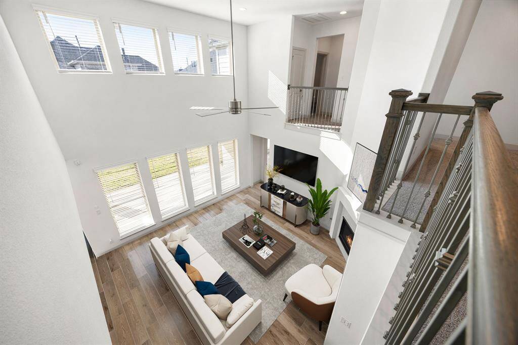 Breathtaking two-story living area with floor-to-ceiling windows and a stylish open layout, perfect for effortless entertaining and relaxation. *Virtually Staged
