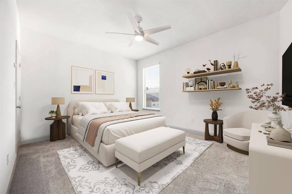 Secondary bedroom features plush carpet, custom paint, dark stained ceiling fan with lighting and a large window with privacy blinds. *Virtually Staged