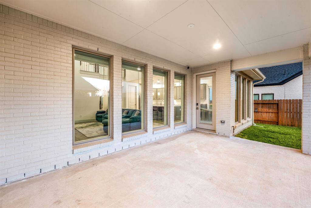 Inviting covered patio with expansive windows that bring the outdoors in, offering a perfect space for relaxation and entertaining alike.