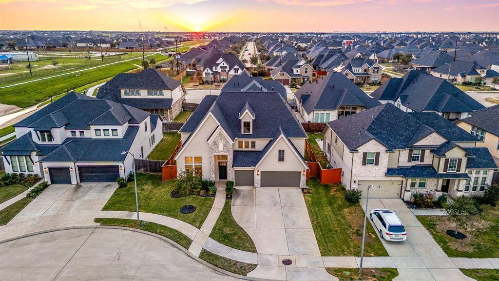 Impressive front elevation set in a welcoming neighborhood, offering striking curb appeal and a glimpse of the surrounding community.