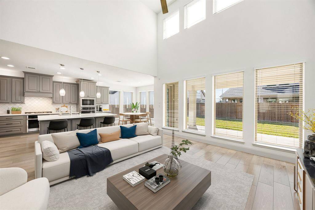 This light and bright spacious living room is the perfect layout for entertaining or just relaxing. Whether it's simply a night in or entertaining family and friends, this home has ample open space for everyone to enjoy! Featuring dark stained ceiling fan, large tile flooring, large windows, soaring high ceilings, recessed lighting with wonderful access to your gorgeous kitchen. *Virtually Staged
