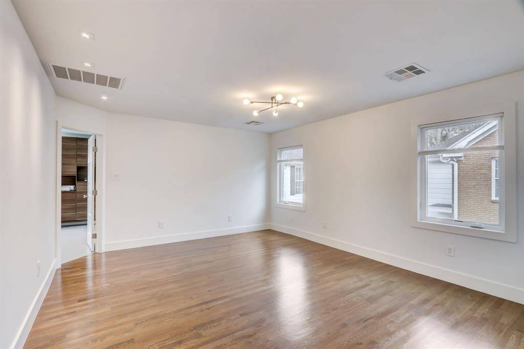 Spacious primary bedroom also has art lights to showcase your most beautiful pieces.