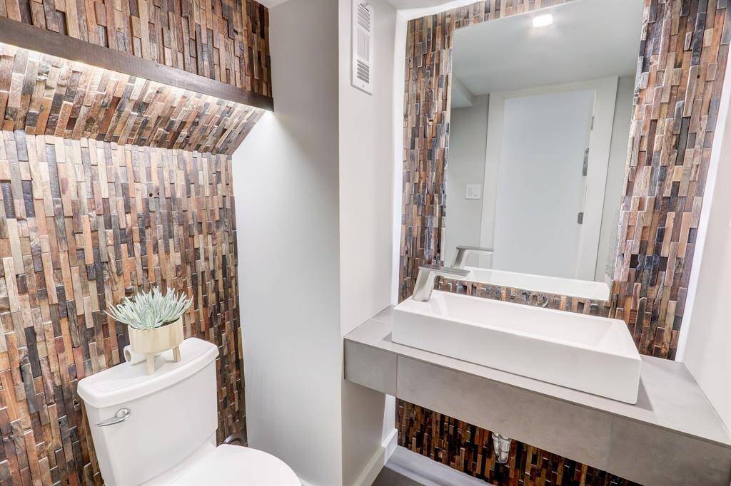 Unique corkboard styled back splash makes this first floor powder bath a true conversation piece.