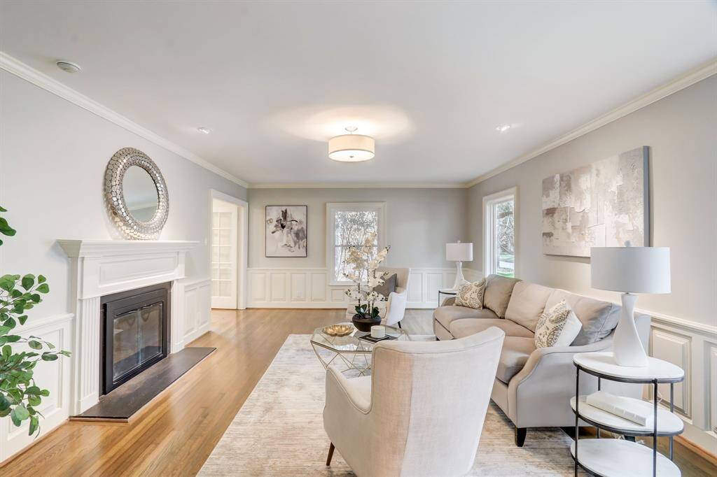 This formal living space features a fire place perfect for winter. Also note the boutique styling lighting, rich hardwoods and crown molding throughout.
