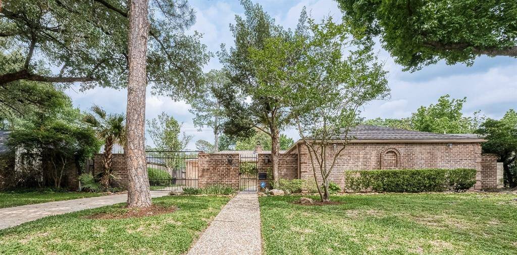Front entrance, gated entry behind brick wall