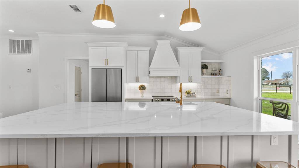 Whether you're whipping up a gourmet meal or simply enjoying a cup of coffee with loved ones, this kitchen with its picture windows and custom touches offers a stylish and practical space where you can cook, dine, and entertain with ease.