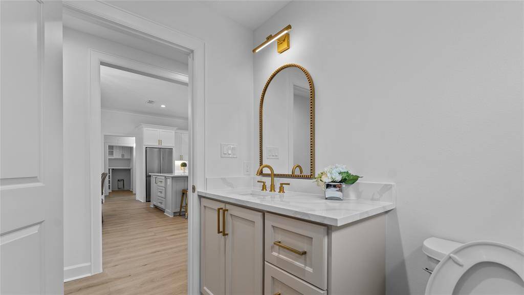 This full bathroom is located just between bedrooms two and three.Features include a custom vanity withshaker style cabinets, coordinating quartzcounters, and gold finishes.