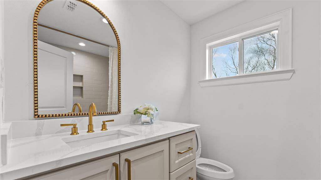 A transom window makes thespace feel light and bright! Take note of the commode that is tucked away for added privacy.