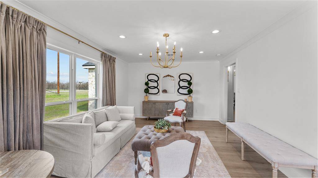The bonus room is bathed in natural light, thanks to large windows that offer views of the surrounding landscape.