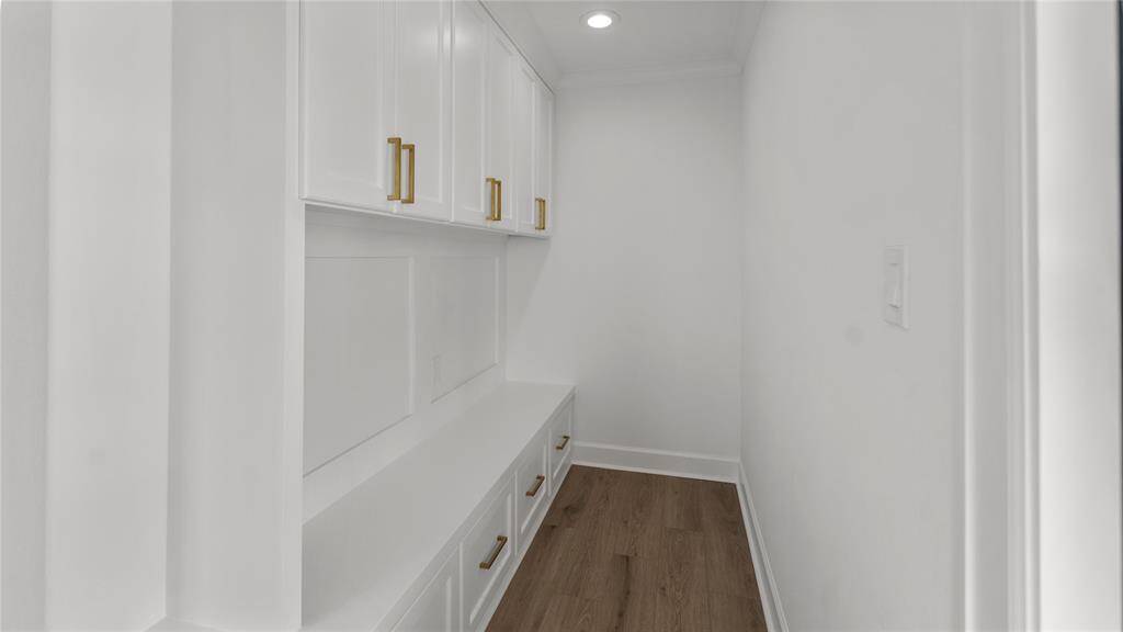 Step into the mudroom—a practical and stylish space designed to keep your home organized and clutter-free. The custom cabinetry with a bench seat and drawers features a timeless design, with clean lines and minimalist hardware that complement the overall aesthetic of the space.