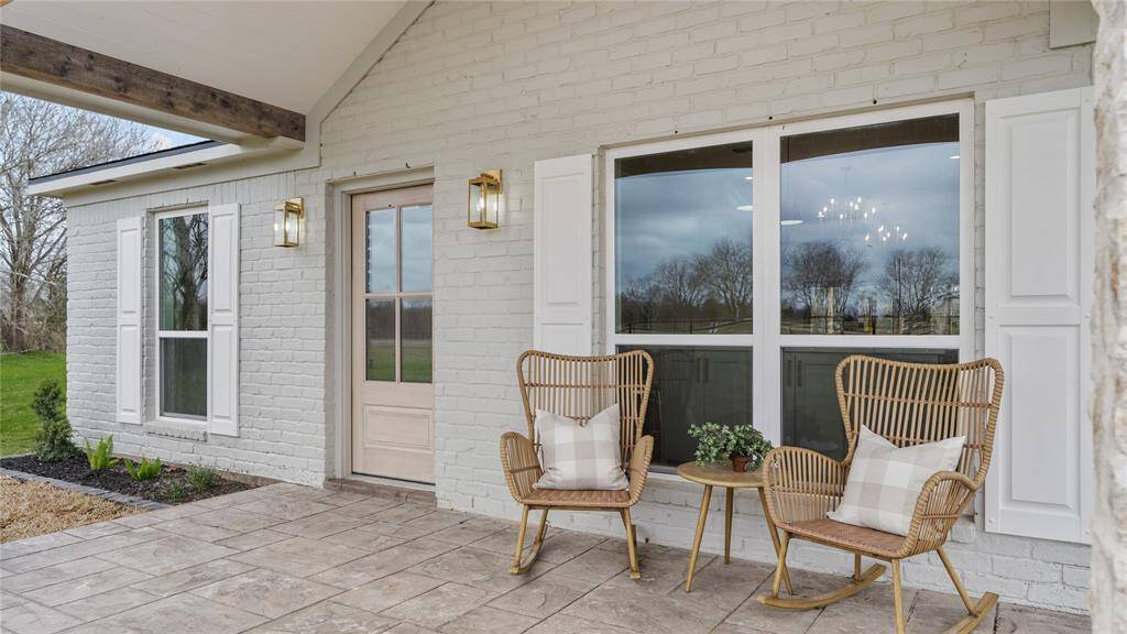 Imagine stepping onto a front porch that epitomizes charm and elegance, with every detail meticulously designed to welcome you home. This front porch, framed by the classic lines of an A-frame roof, beckons you with its timeless appeal and graceful simplicity. Golden coach lights flank the entrance, their soft glow casting a warm and welcoming light that guides your way.