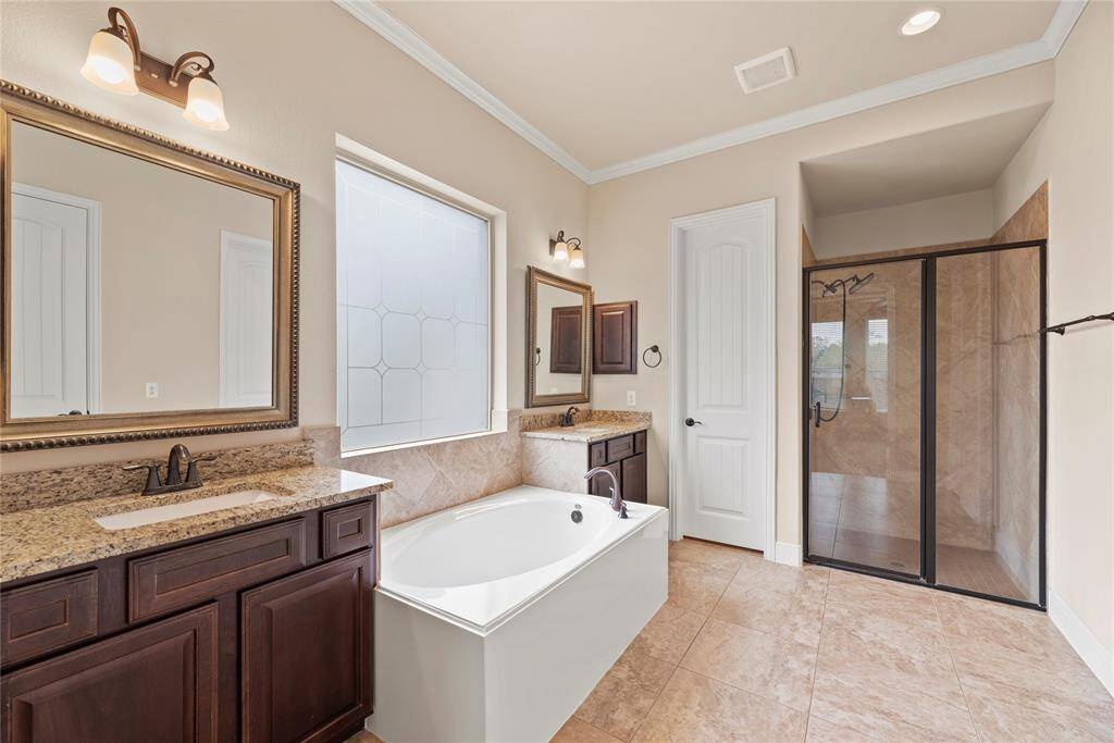 primary bath with double sinks and separate soaking tub