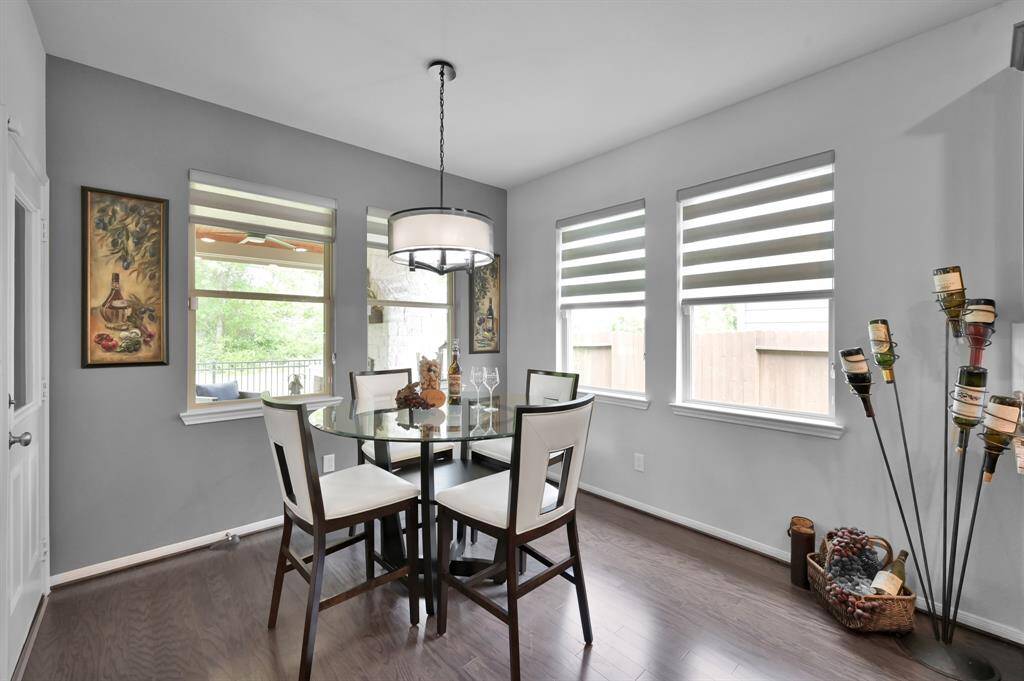 Bright breakfast area ,featuring large windows with Zebra shades offering plenty of natural light, complemented with a chic light fixture.