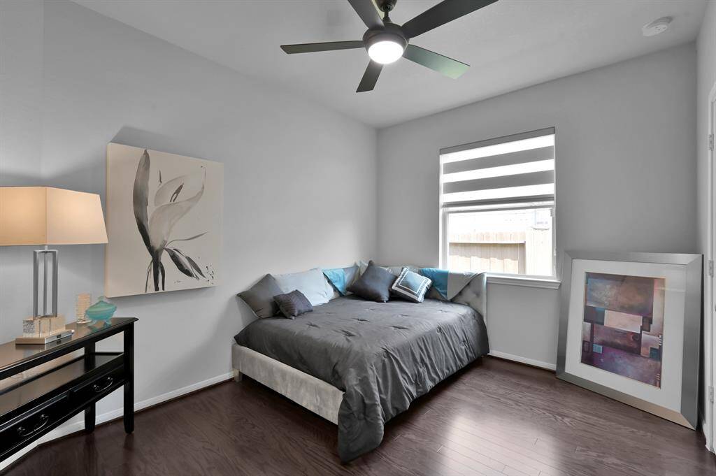 The 3rd bedroom with modern decor featuring a ceiling fan, Zebra window shades, creating a stylish and comfortable space.