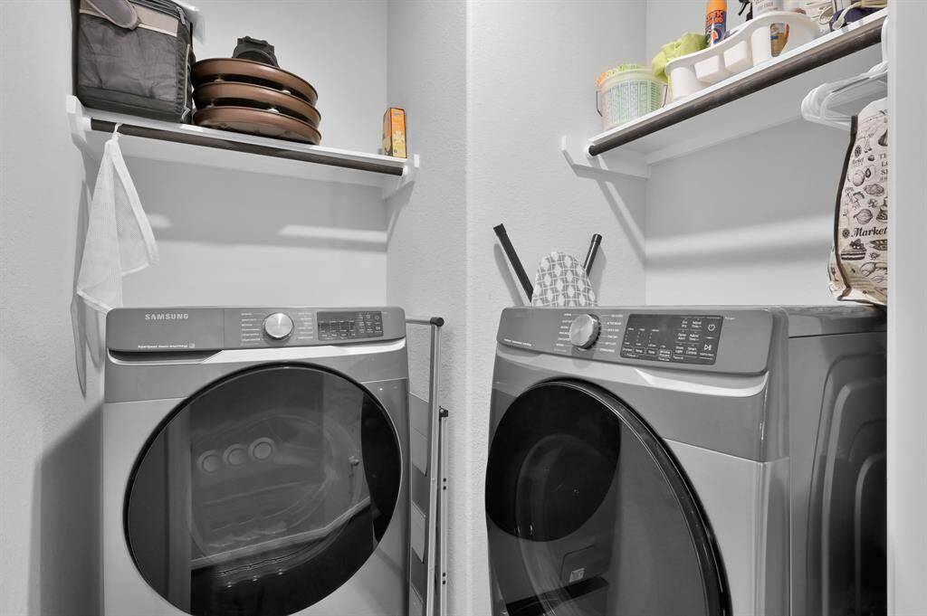 The laundry room features shelving providing storage for laundry essentials and other items, maximizing space efficiency.