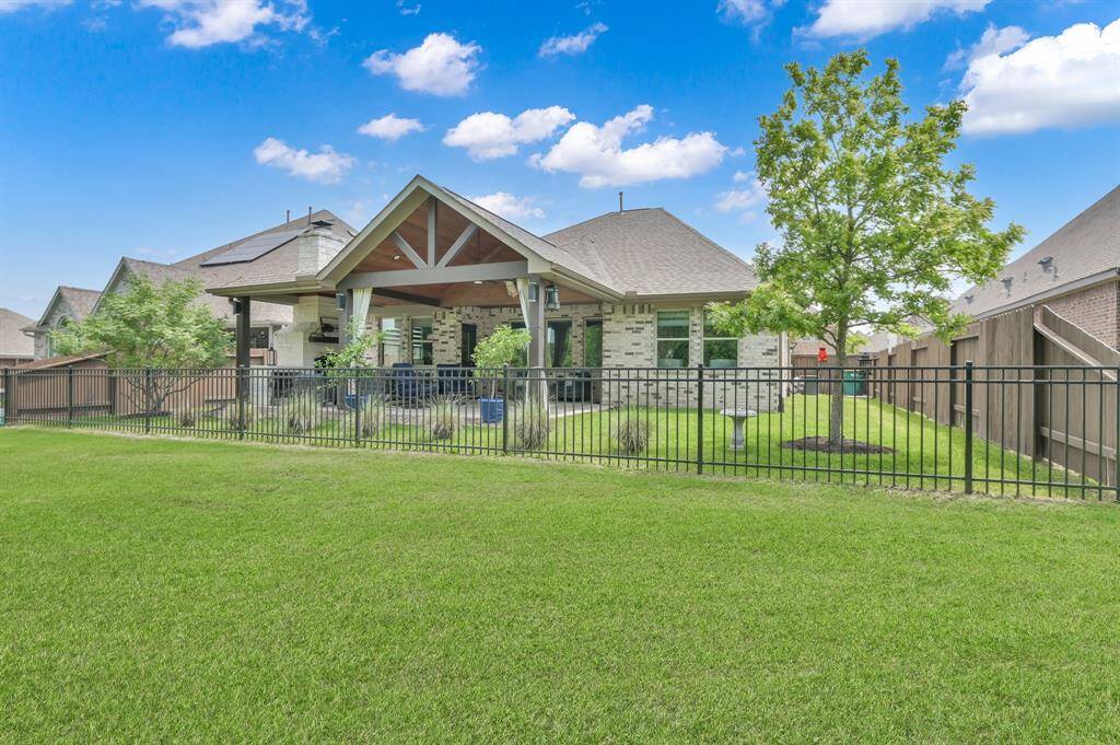 Spacious backyard with a well-maintained lawn, fully fenced for privacy. Ideal for outdoor gatherings.