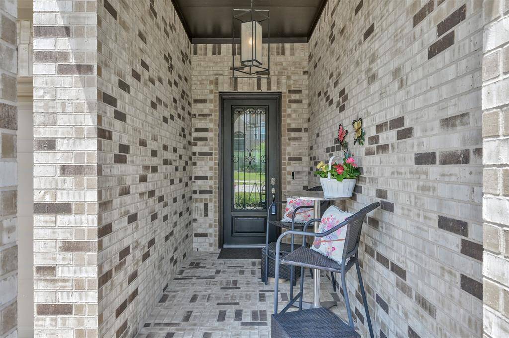 This cozy entryway features a charming brick design with a decorative black door.