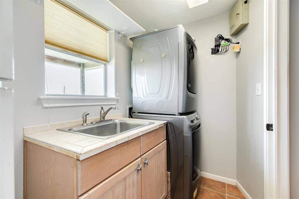 Utility room on first level with washer, dryer, extra refrigerator and soaking basin