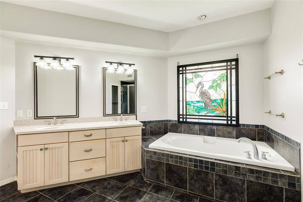 Primary soaking tub, stained glass over the window & dual basins