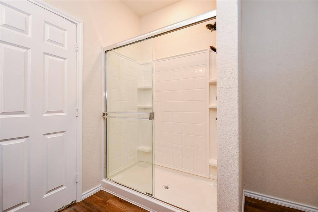 Notice the clean and modern design of the shower itself, featuring built-in shelving for easy storage.