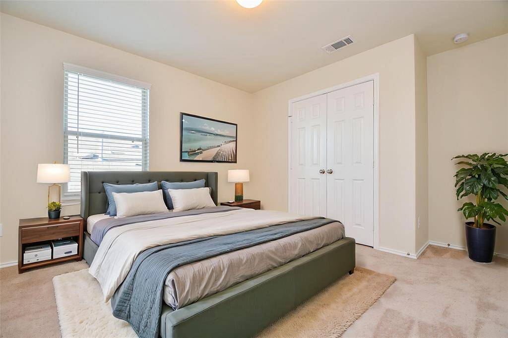 Step into this spacious fourth bedroom, which features plush carpeting and neutral walls. The double doors provide ample closet space and offer convenient storage.