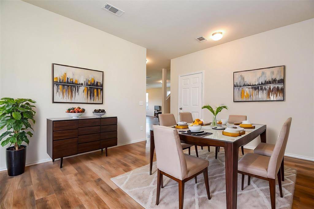 Natural light floods the room through the window, highlighting the beautiful flooring and neutral walls.