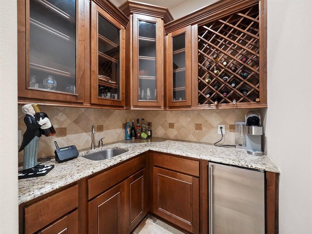 Indulge in the convenience and sophistication of a dedicated butler's pantry and wine cellar. This exquisite feature boasts a wine cooler and sink, providing the perfect space for storing and serving your favorite vintages while adding a touch of elegance to your home.