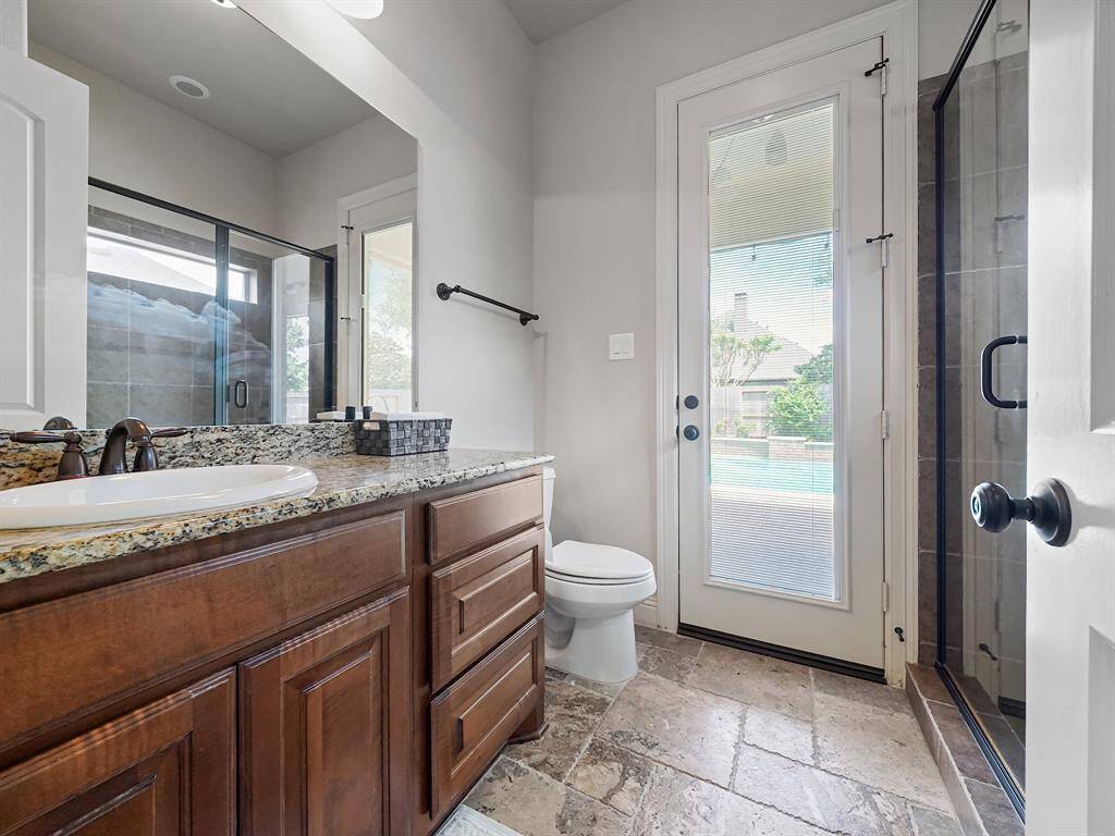 Step into luxury with this exceptional secondary bedroom ensuite, complete with a private ensuite bathroom. Imagine the convenience of an oversized shower and, best of all, direct access to the backyard oasis! Perfect for swimmers or anyone enjoying the outdoor space, this bathroom provides effortless convenience, allowing you to rinse off without tracking water through the rest of the home. This thoughtful design blends indoor comfort with outdoor living, creating a truly seamless experience.
