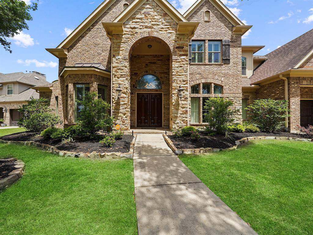 From the moment you arrive, the stunning curb appeal captivates with its elegant stone and brick exterior, complemented by mature trees and beautifully maintained landscaping.