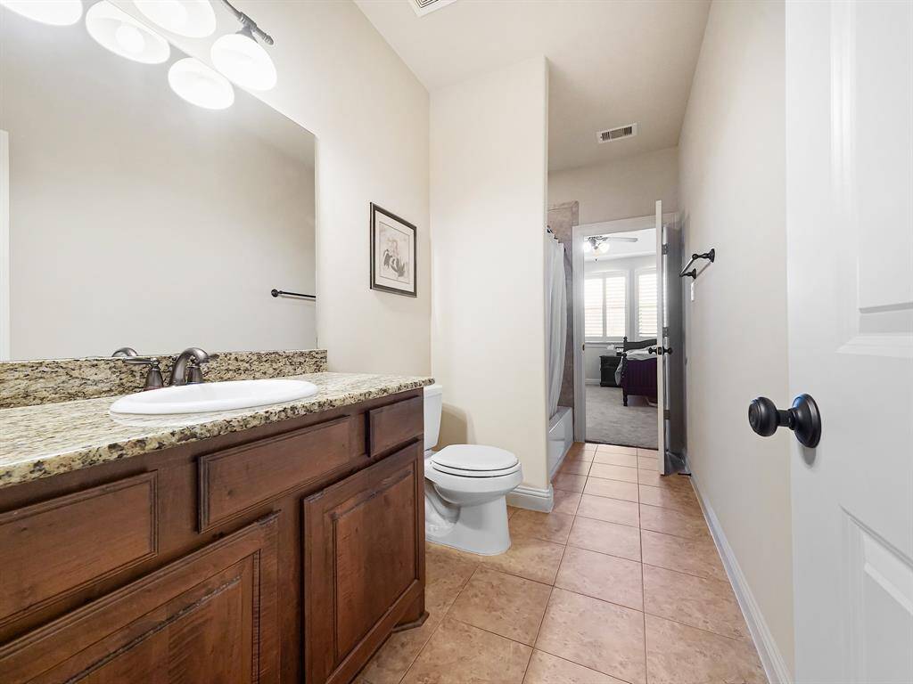 Second-floor bathroom boasts a large granite vanity, stained cabinets, and a shower/tub combo. Accessible from hallway and one of the secondary bedrooms!