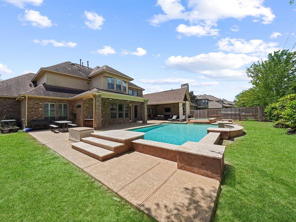 Step outside into your own private paradise – a stunning backyard oasis featuring a heated pool and spa, perfect for year-round enjoyment.