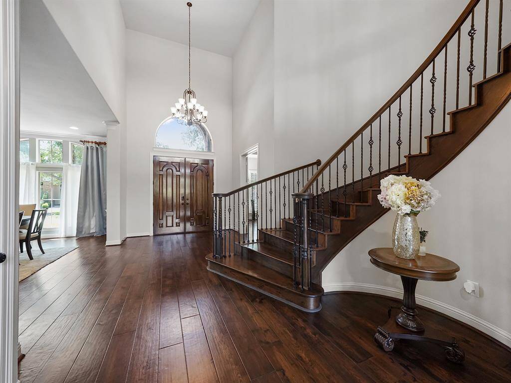 Alternative view of the foyer showcasing the elegant lighting and arched clerestory window above the front entry.