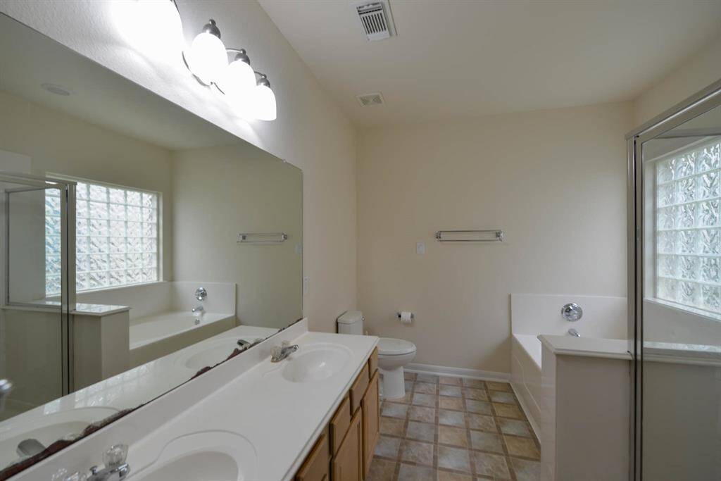 Experience the luxury of the owner's bath with dual sinks and bright lighting, perfect for your daily routine.