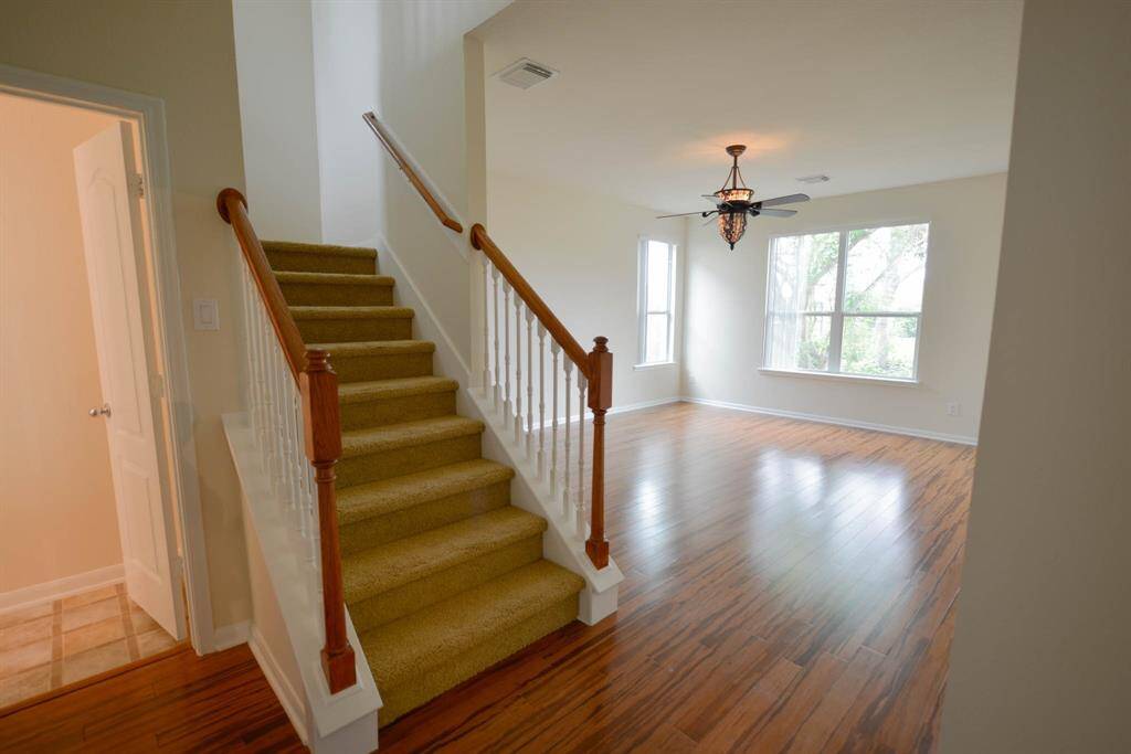 Discover the elegance of the owner's suite, featuring a stunning light fixture and sleek bamboo flooring, with direct access to the upstairs study for added convenience.
