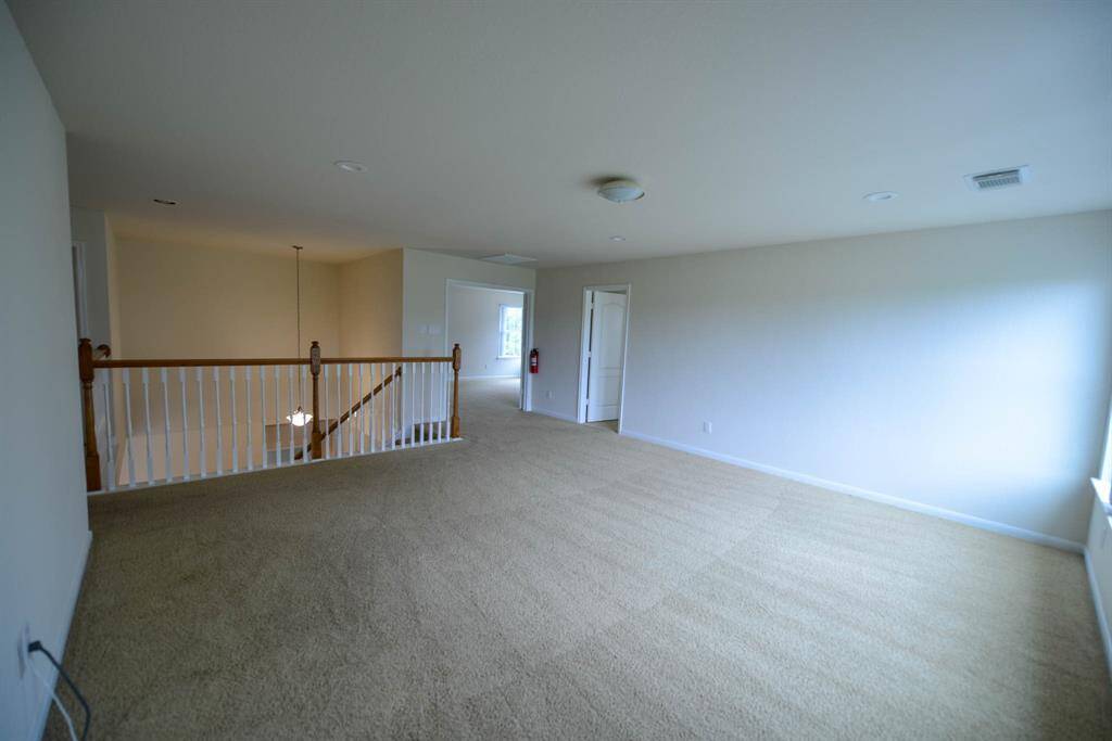 Spacious upstairs game room ideal for a pool table and family fun.