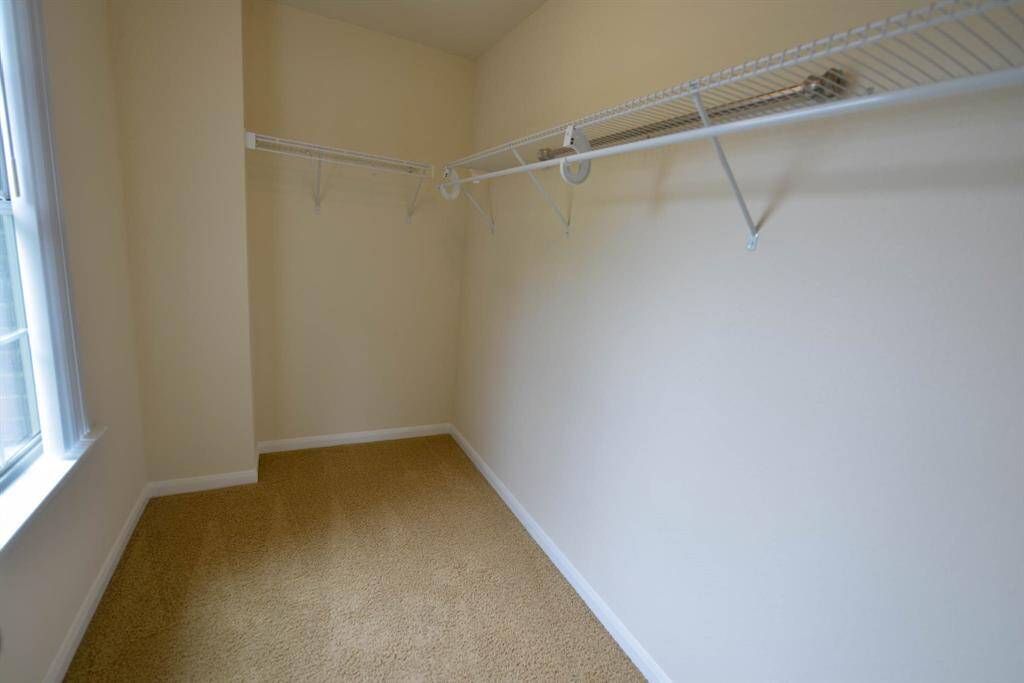 Bright walk-in closet in the front bedroom with a window for natural light.
