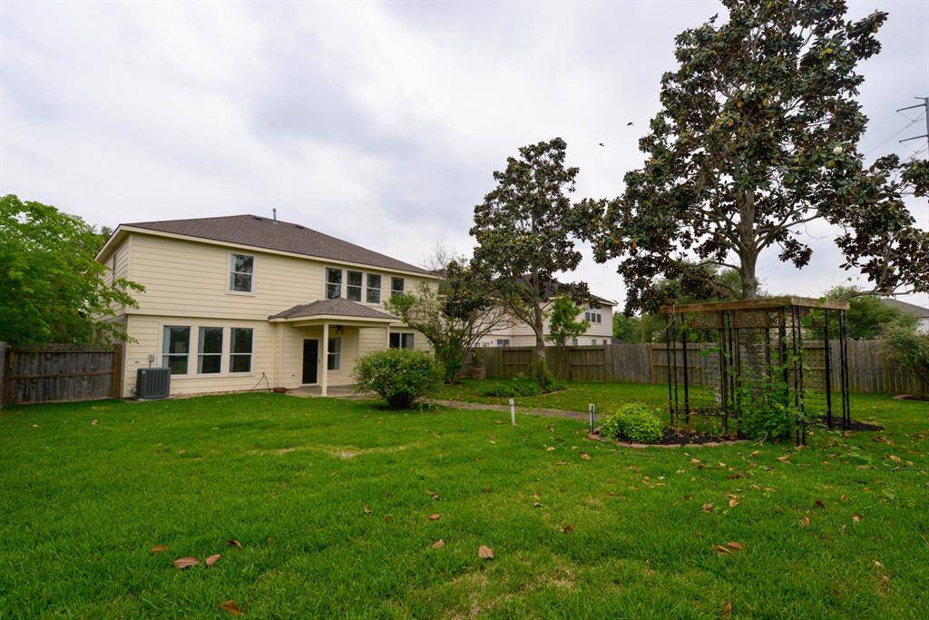 Expansive, private backyard featuring an arbor, a charming porch swing, and convenient extra electrical outlets. Perfect for relaxation and outdoor activities.