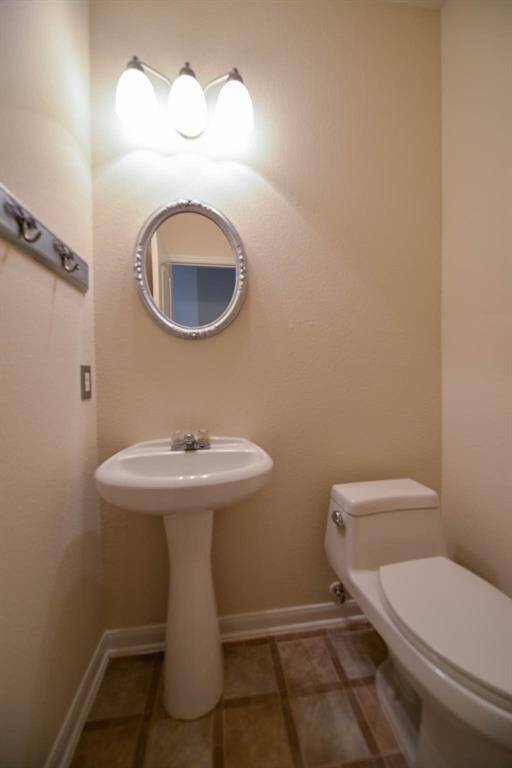 Cozy powder room featuring a stylish pedestal sink and fresh, modern paint.