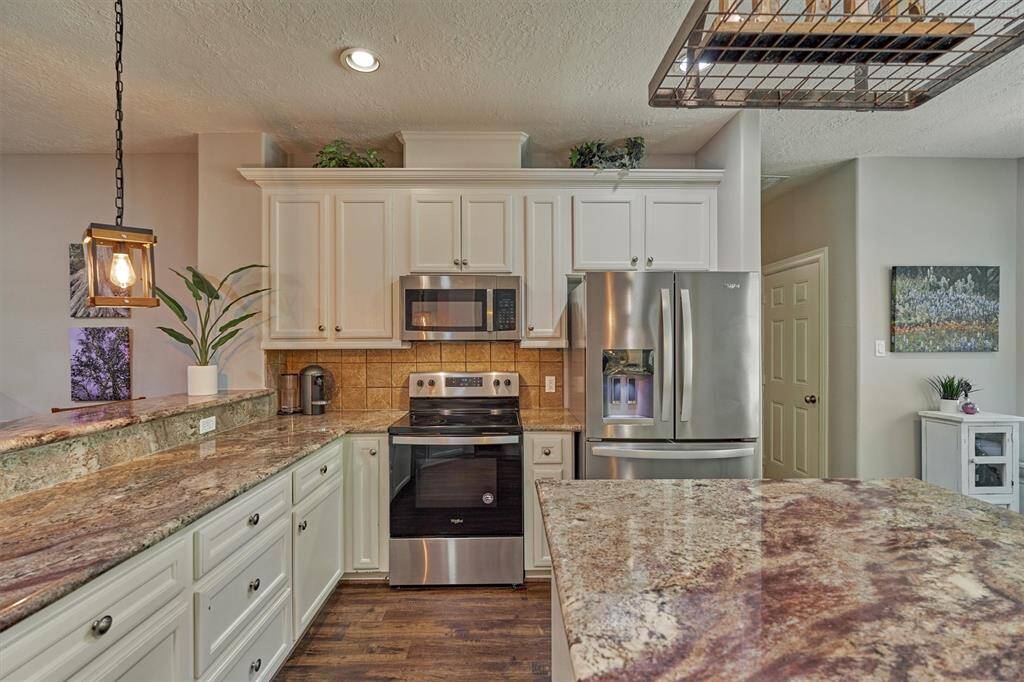 The kitchen features granite counters, stainless appliances, and a central island.