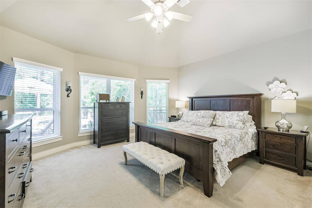 Step inside the serene primary suite, complete with large windows that flood the space with natural light and offer peaceful views of the backyard oasis. The neutral palette and vaulted ceiling create a calming retreat, perfect for unwinding at the end of the day.