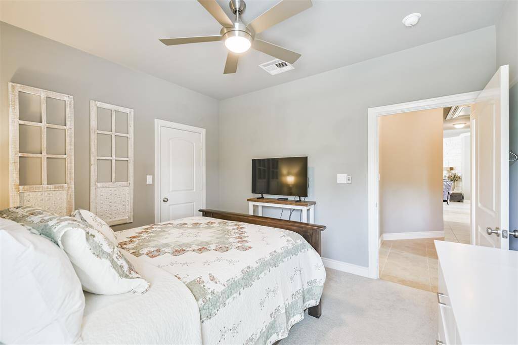 This bedroom is conveniently located near a large shared bathroom.