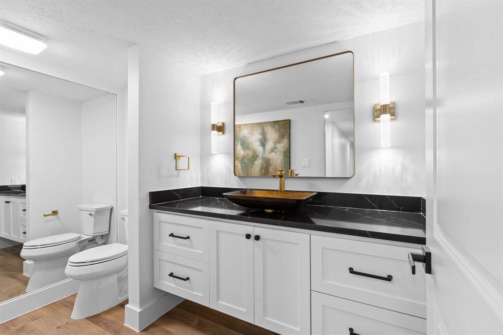 Modern half bath with upgraded cabinets, lights, mirror and sink.