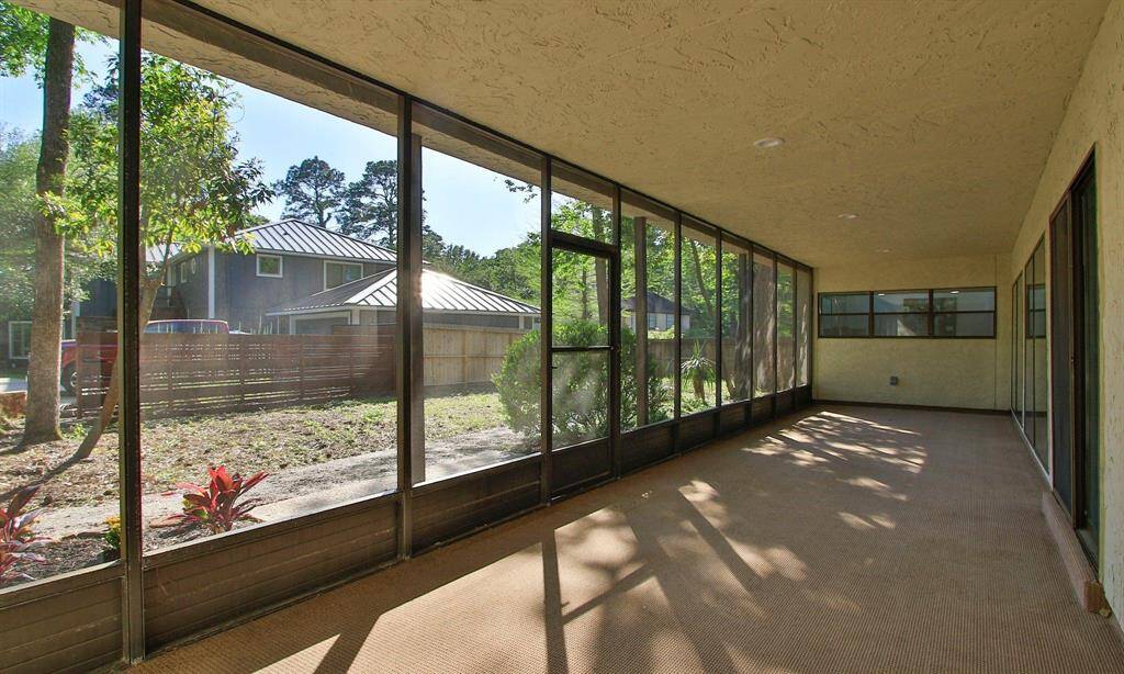 Looking through the wall of windows along the living and breakfast room is a screened in porch.