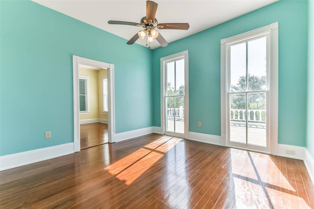 Another large 2nd floor bedroom with large windows that lead out to the front deck over the enclosed front porch which overlooks Avenue O.