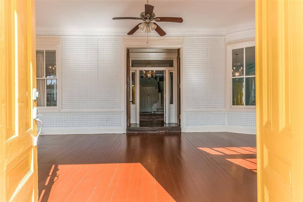Step into a spacious 45 x 15 enclosed front porch, bathed in natural light from nine sets of elegant double doors, and cooled by three stylish ceiling fans. This grand entrance, once graced by the Houston Ballet Foundation, sets a sophisticated tone for this magnificent home.