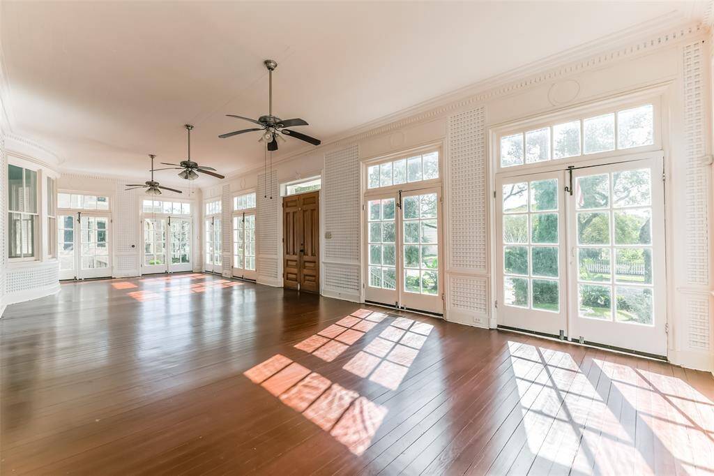 Step into a spacious 44 x 16 enclosed front porch, bathed in natural light from nine sets of elegant double doors, and cooled by three stylish ceiling fans. This grand entrance, once graced by the Houston Ballet Foundation, sets a sophisticated tone for this magnificent home.
