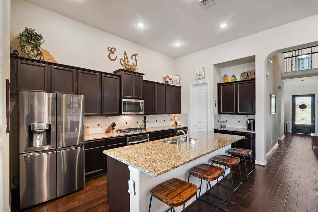 The luxury kitchen in this home features high-end stainless-steel appliances and provides a view of the dining area.