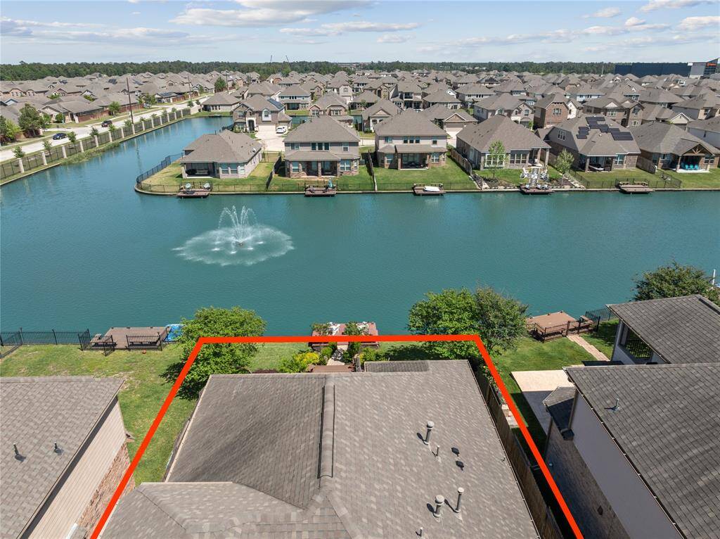 Amazing Aerial Shot of Back of Home showing a beautiful view of the lake and fountain.