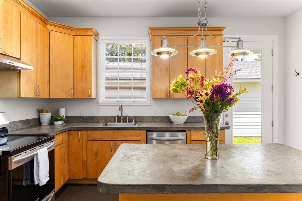 Fall in love with the sleek, modern cement countertops in this beautifully renovated kitchen.