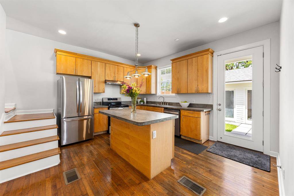 Convenient staircase off the kitchen leads directly to the upstairs bedrooms. Cement counters with stainless appliance package are a neutral tone with endless possibilities.